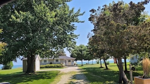 Un chemin de gravier mène à une maison d’où l’on a vue sur la mer.