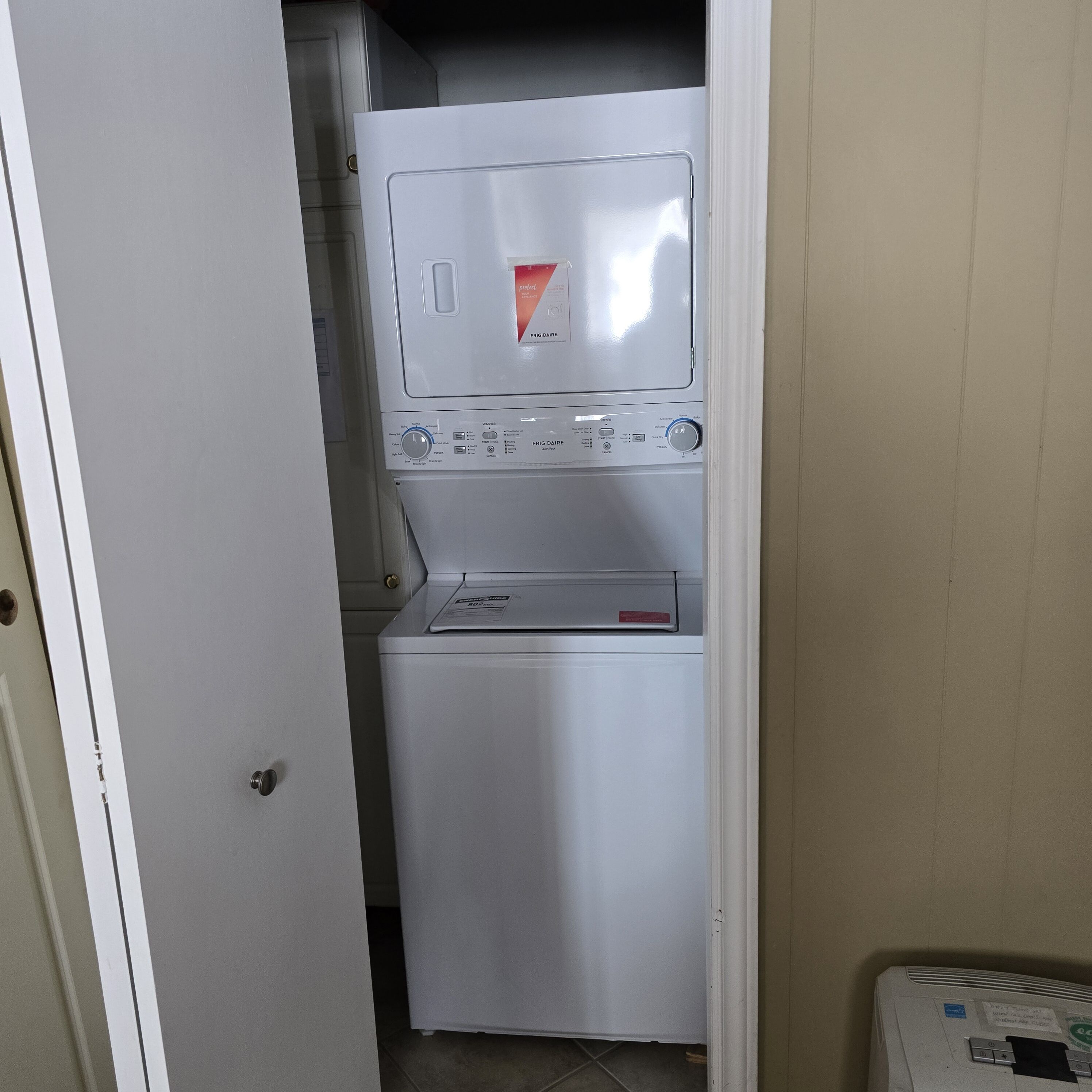 Een kleine wasruimte met een voorlader wasmachine en droger.