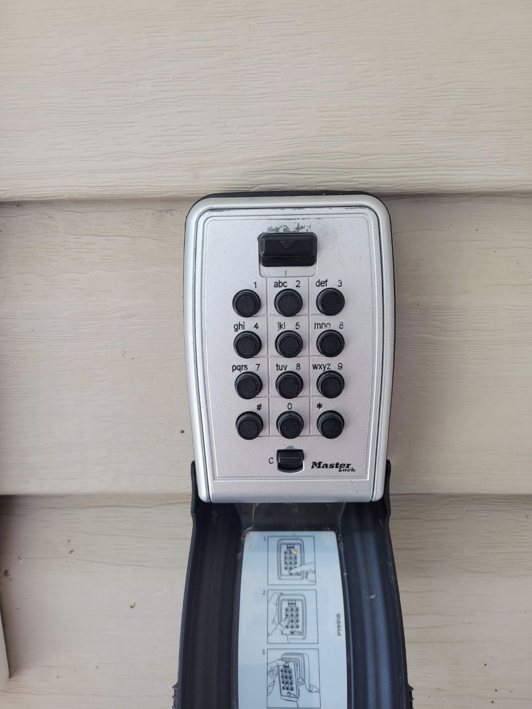 A keypad with a "Master" label, a small display, and a paper with diagrams.