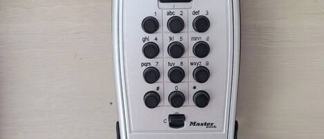 A keypad with a "Master" label, a small display, and a paper with diagrams.