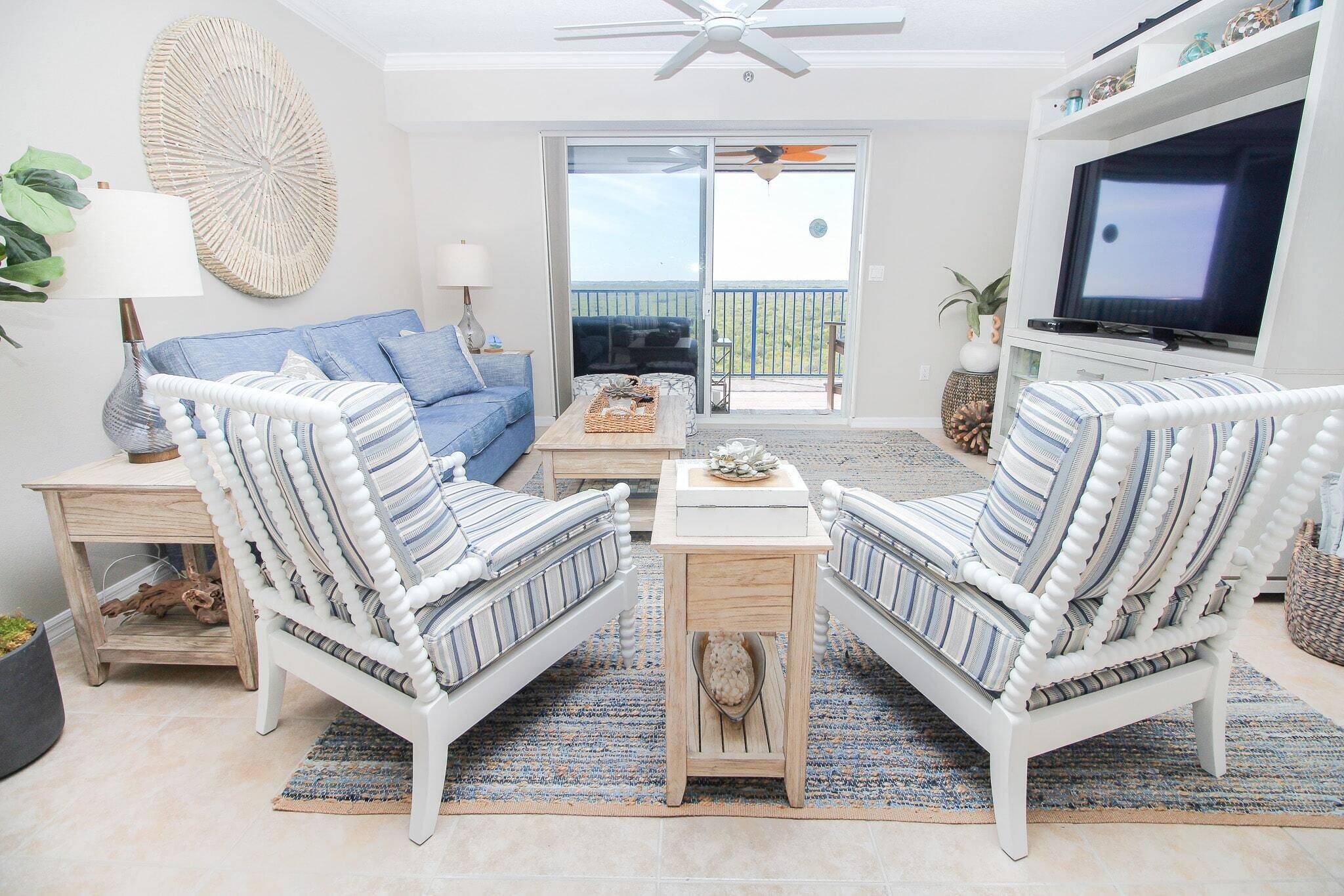 A living room with a sofa, two armchairs, a coffee table, and a TV.