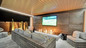 A modern outdoor lounge area with a flat-screen TV, comfortable seating, and a fire feature. -  Large Groups Welcome! Newly Added Pickleball Court!
 (Scottsdale)