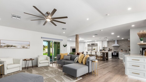 A spacious living area with a grey sofa, a white armchair, and a grey ottoman. There is a kitchen in the background with white cabinets and a stainless steel refrigerator. -  Large Groups Welcome! Newly Added Pickleball Court!
 (Scottsdale)