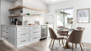 A modern kitchen with white cabinetry, a built-in oven, and a dining area with a round table and chairs. -  Large Groups Welcome! Newly Added Pickleball Court!
 (Scottsdale)