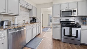 A modern kitchen with stainless steel appliances, white cabinetry, and a granite countertop. - Lookin' and Feelin' Good in Georgetown - Long stays / Pets / Office (Georgetown)