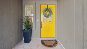 A yellow door with a wreath, a potted plant, and a doormat. - Lookin' and Feelin' Good in Georgetown - Long stays / Pets / Office (Georgetown)