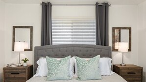 A bedroom with a large bed, two nightstands, a window with blinds, and two wall-mounted mirrors. - Lookin' and Feelin' Good in Georgetown - Long stays / Pets / Office (Georgetown)