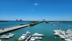 A marina with multiple yachts docked, a bridge in the background, and a clear blue sky. - Bayfront  apartment with Breathtaking views.   1 bdr w/ balcony . Free Parking (North Bay Village)