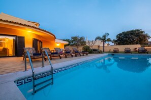 A swimming pool with lounge chairs and a building with a tiled roof. - Family retreat w/ pool & BBQ in Montechoro (Albufeira)