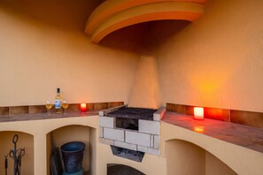 A cozy outdoor seating area with a built-in grill, a bottle of liquor, and two glasses. - Family retreat w/ pool & BBQ in Montechoro (Albufeira)
