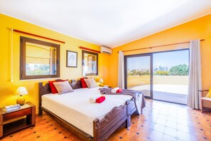 Une chambre d’hôtel avec un grand lit, un balcon et une vue sur la ville.