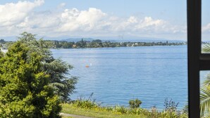 A lake with a view of a distant shoreline, trees, and a clear sky. - Lakeside Terrace - Taupo Holiday Home (Taupo)