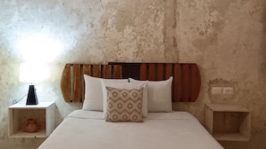A bedroom with a large bed, a wooden headboard, a bedside table with a lamp, and an air conditioning unit above the bed. - HOSTEL VALLADOLID 48 (Valladolid)