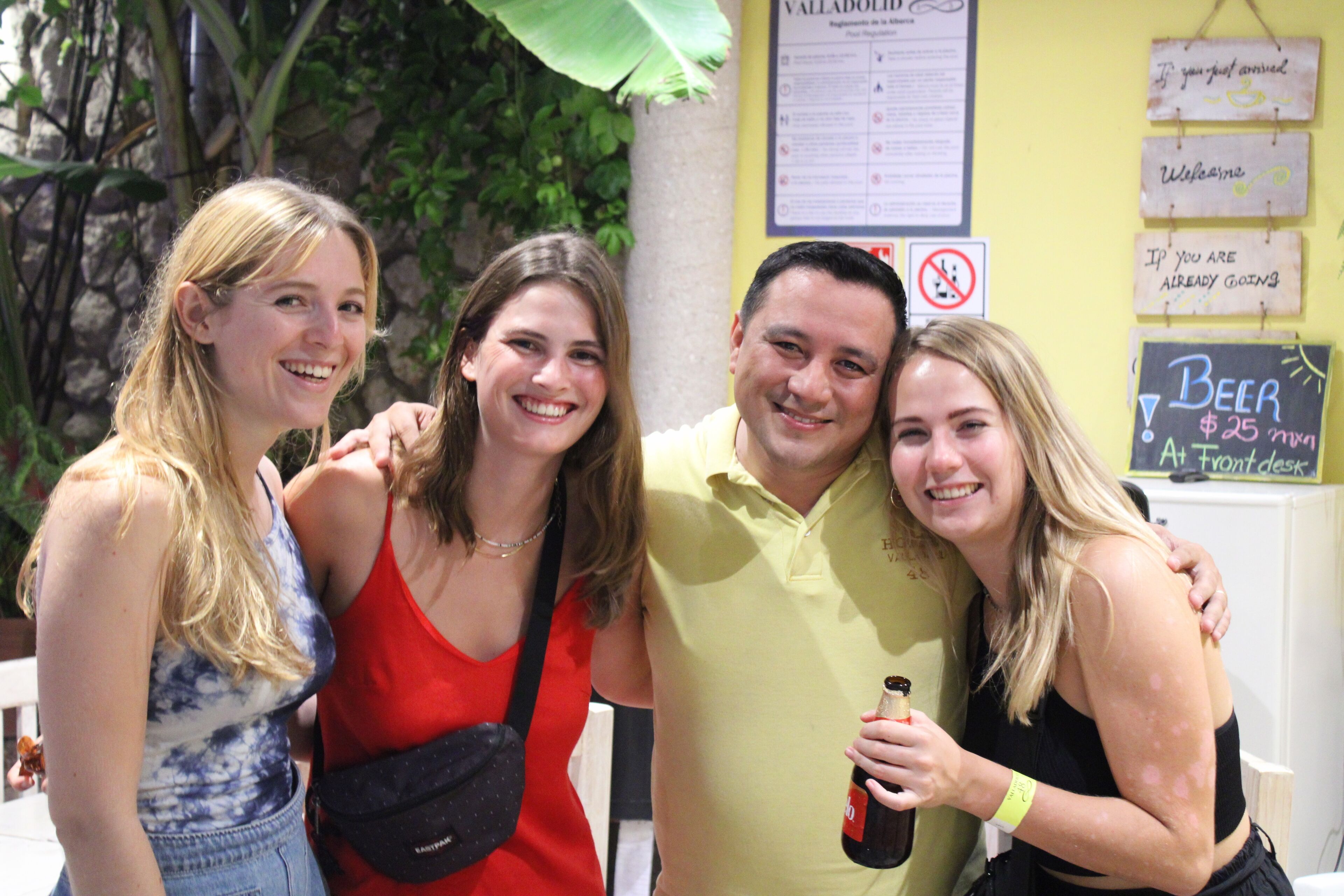 Un grupo de personas reunidas al aire libre, con un cartel que indica el precio de la cerveza: 25 dólares.