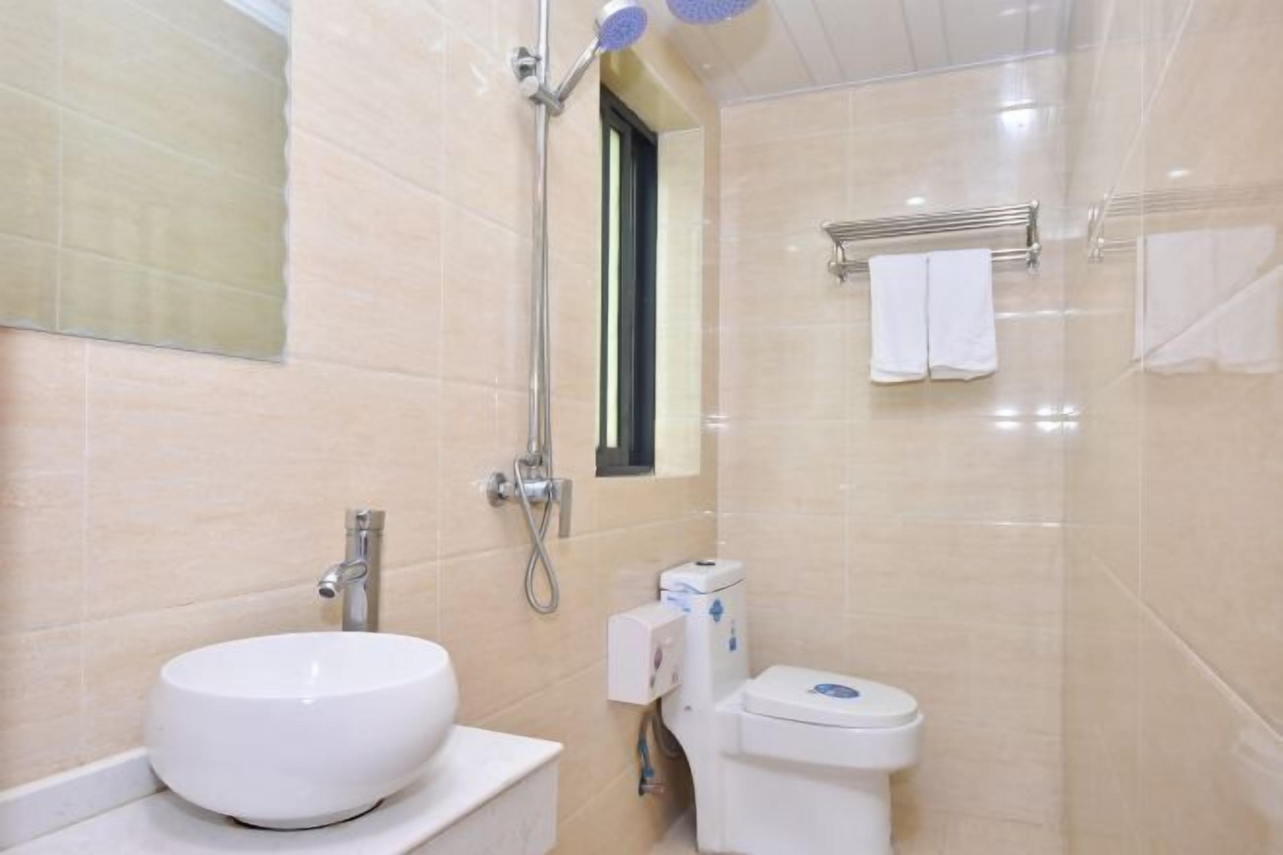 Een badkamer met een wit wastafel, toilet en douche.