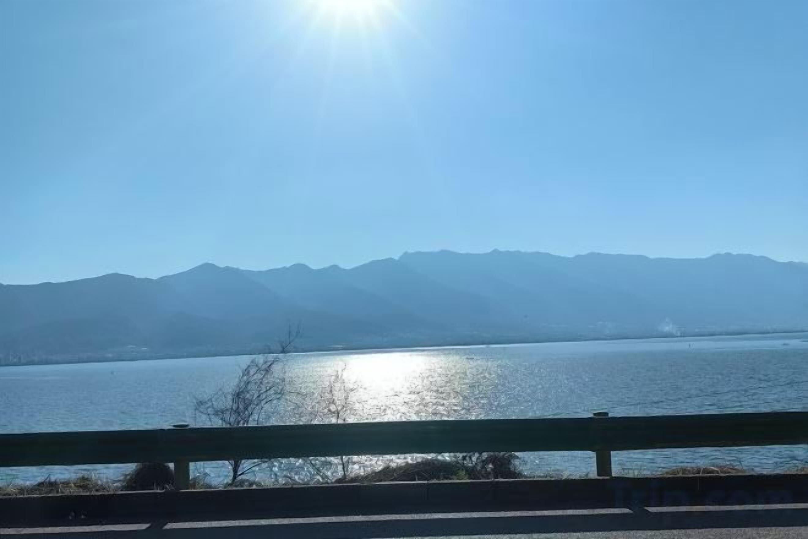 A body of water with mountains in the background and a clear sky.