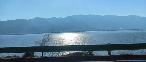 A body of water with mountains in the background and a clear sky.