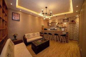A modern living room with a sofa, coffee table, and bar stools.