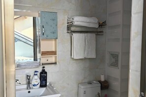 A bathroom with a sink, mirror, towel rack, and toiletries. - Hmyway (Dali City)