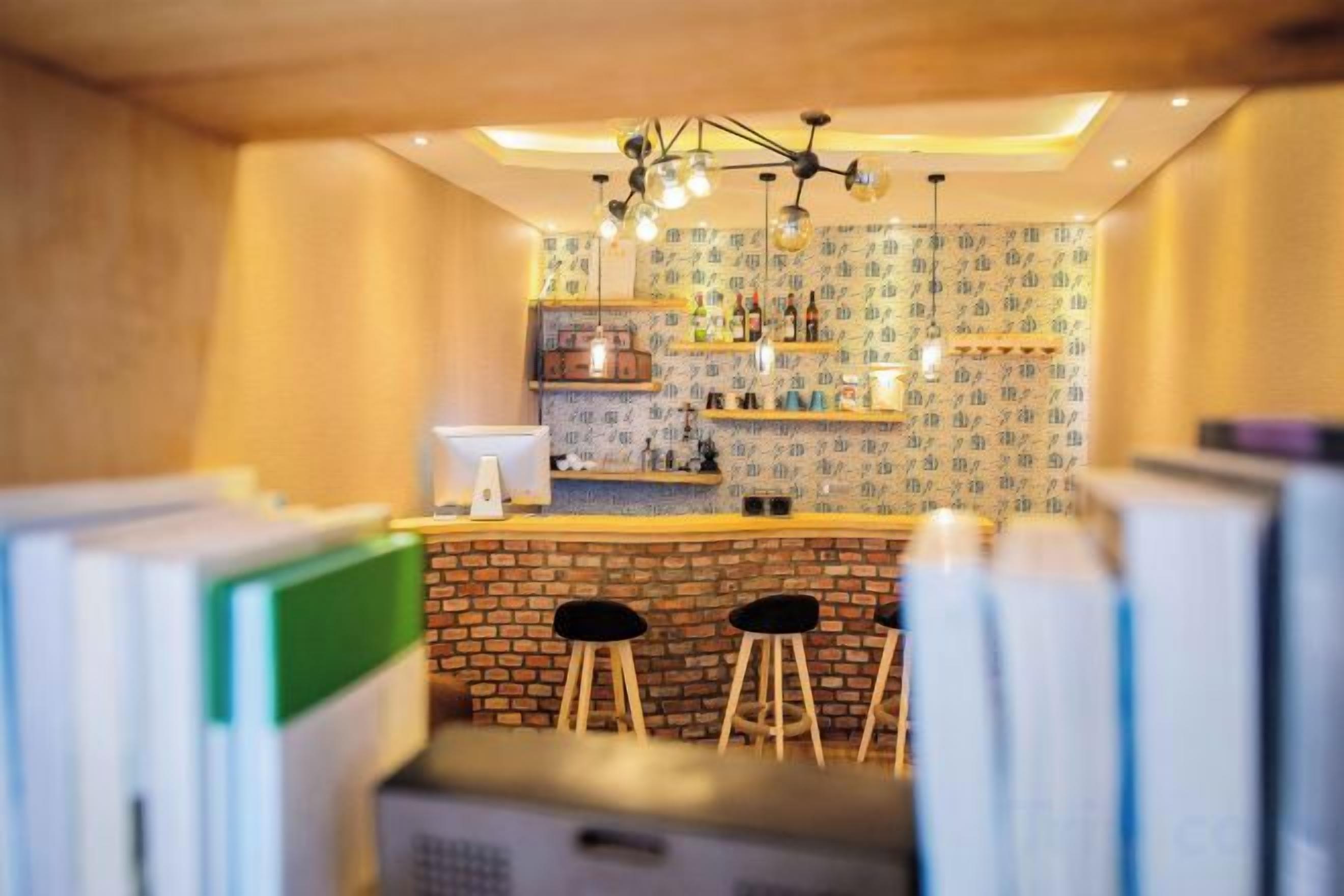 A bar area with a brick counter, stools, and shelves with bottles. - Hmyway (Dali City)
