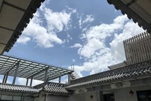 A traditional building with a tiled roof and a partially visible interior structure.