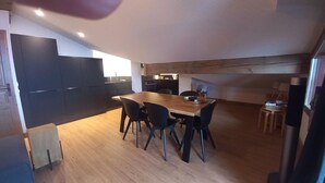 A modern kitchen with a wooden dining table and black chairs. - B302 - 68 m2 - 3 chambres-duplex - 6 pers (Prapoutel)