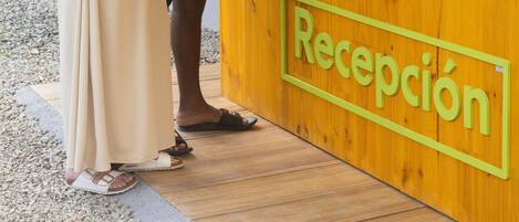 A reception desk with a sign reading "Recepción" at a resort.