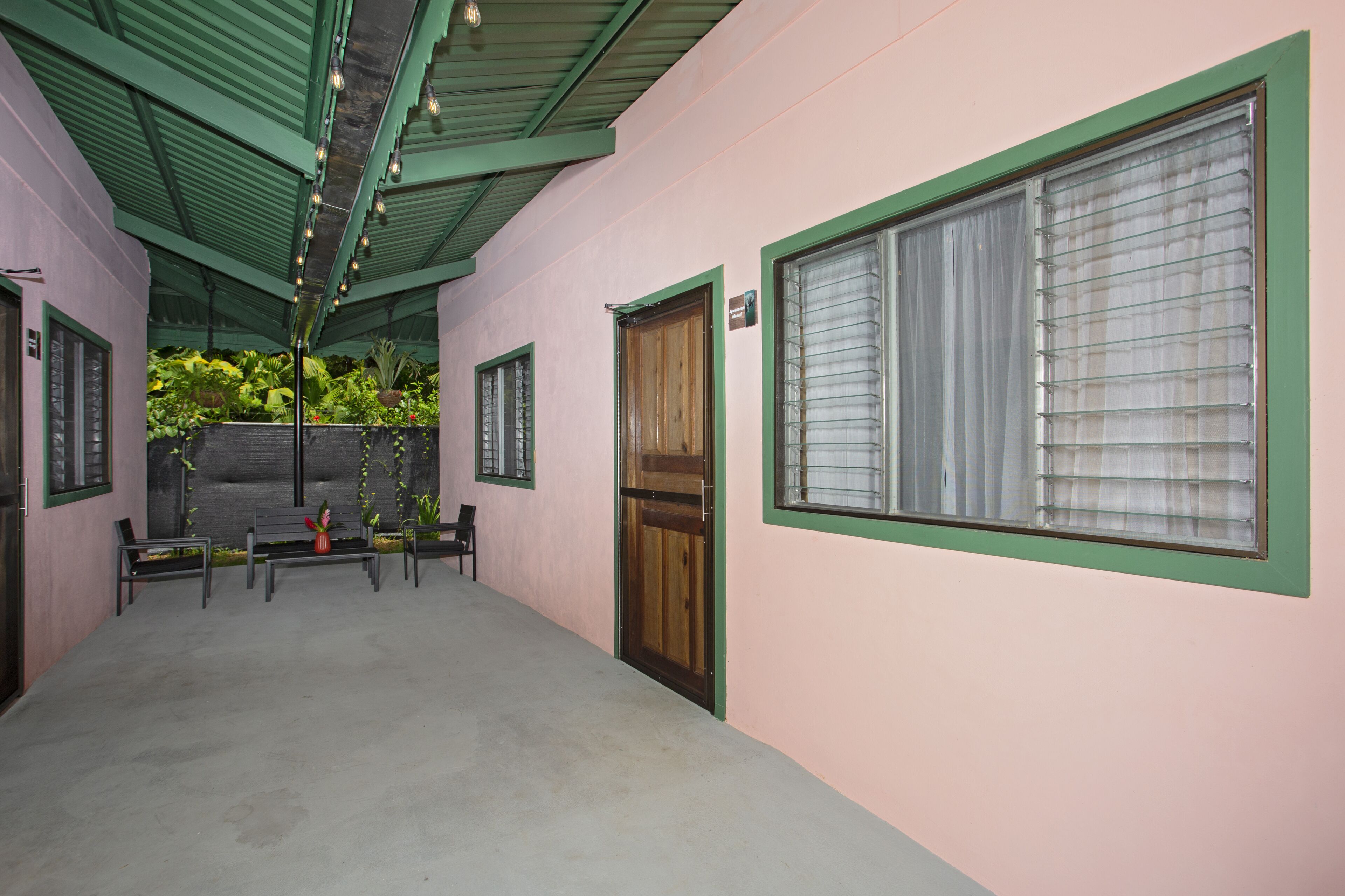 A corridor with benches, a wooden door, and a window with blinds.