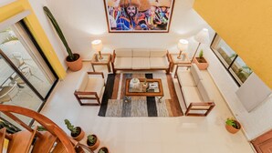 A modern living room with a sofa set, a coffee table, and potted plants. - Zoque's Mexican Villa (Cancún)