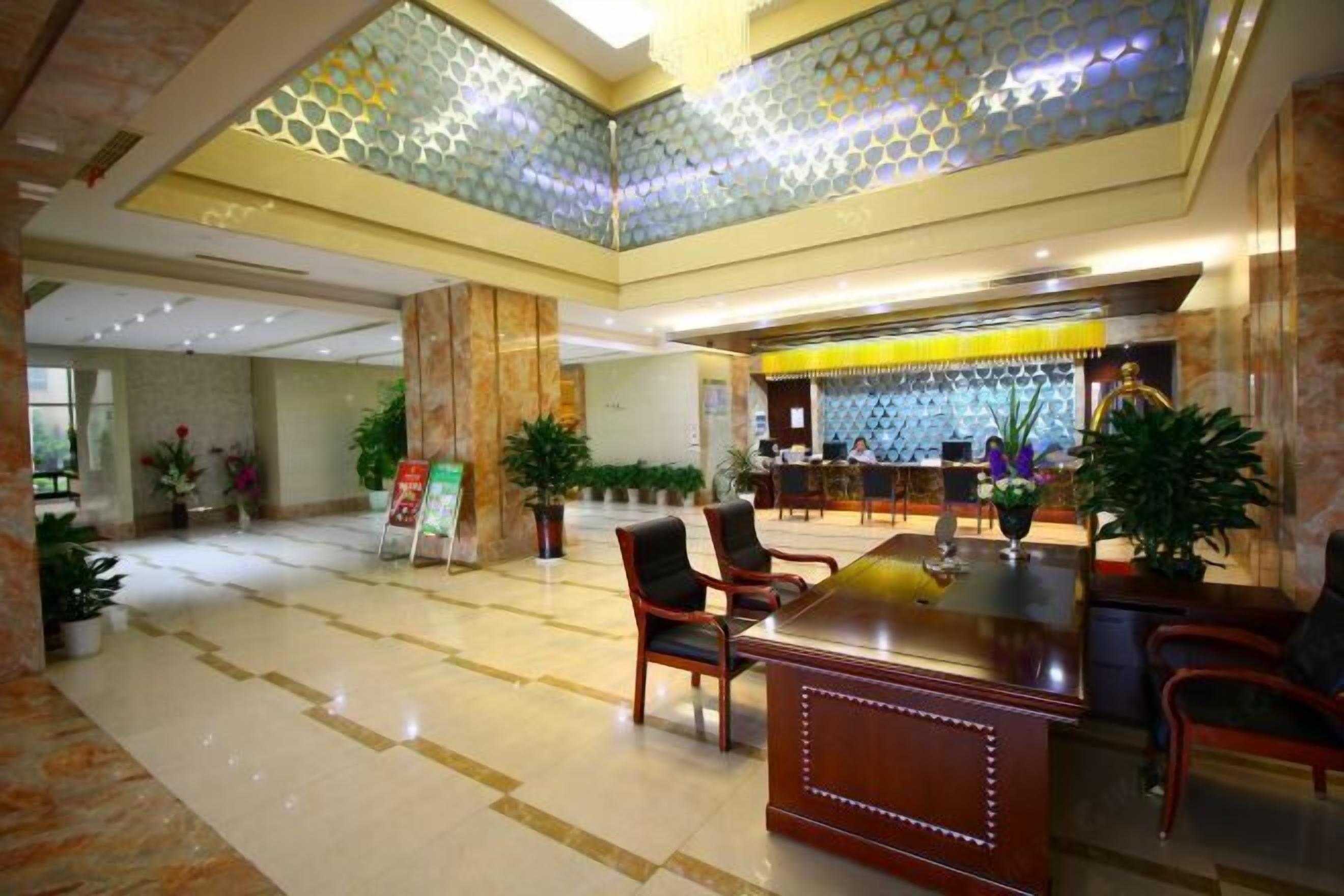 A spacious lobby with a reception desk, seating area, and decorative elements.