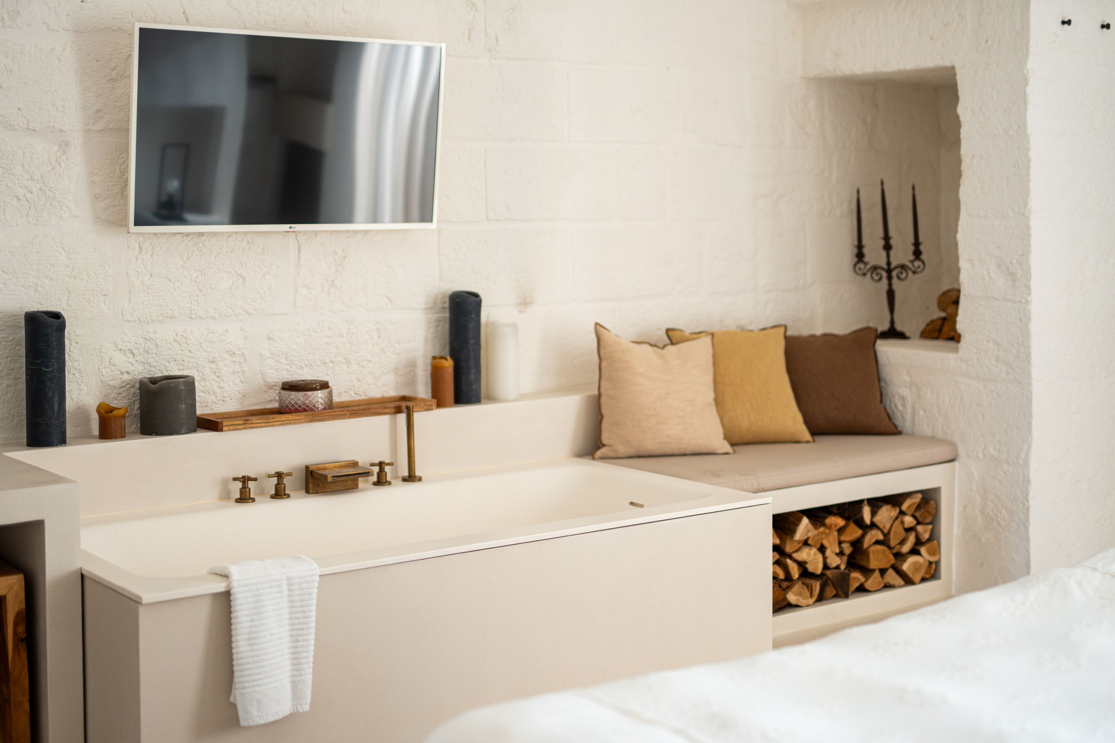 A modern bathroom with a large sink, a mirror, and a television mounted on the wall.