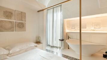 Une salle de bain moderne avec une baignoire sur pieds, un grand miroir et un meuble-lavabo.