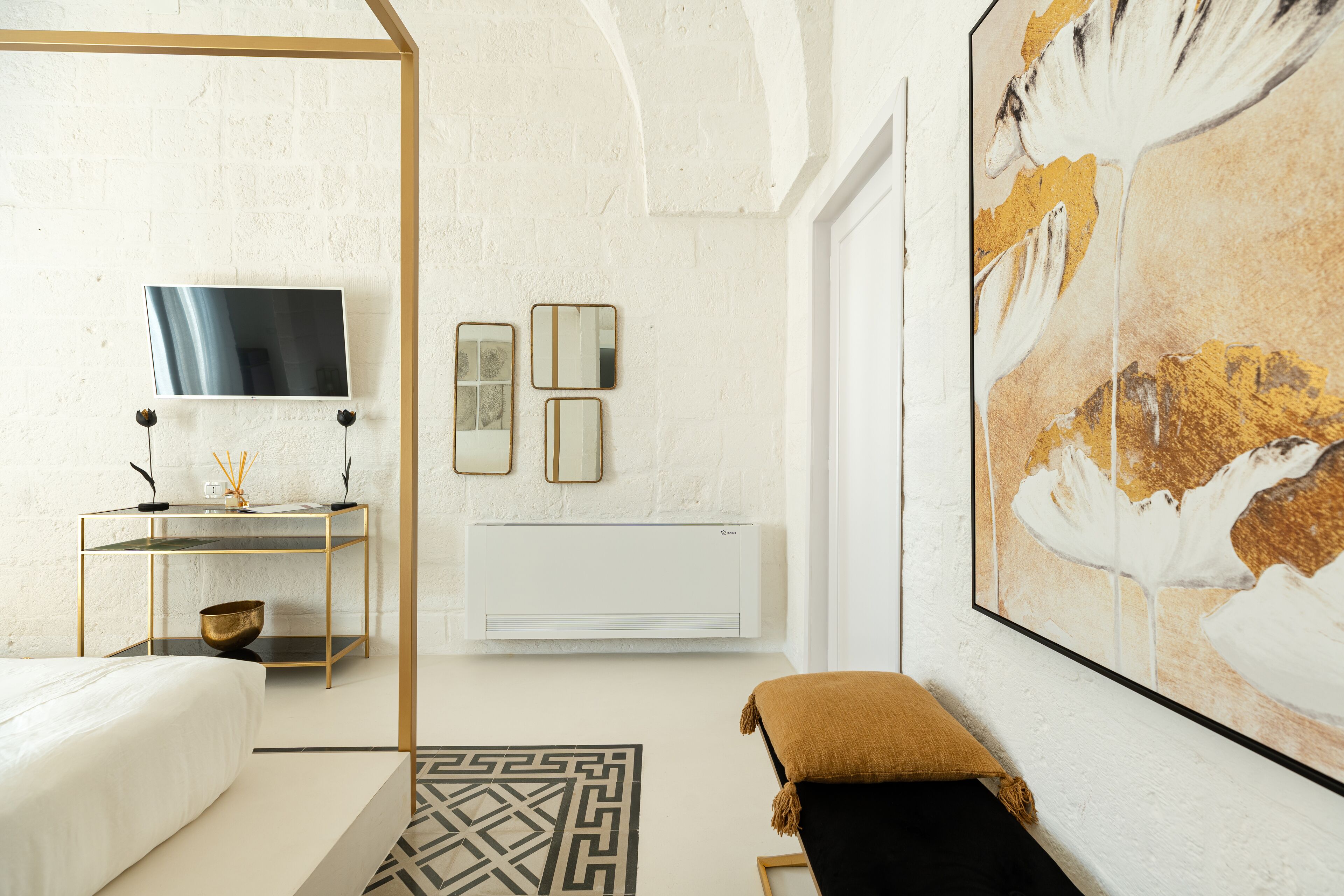A modern bedroom with a bed, bedside table, and a large abstract painting.