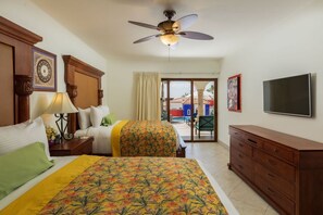 A hotel room with two beds, a ceiling fan, a TV, and a view of the outside. - Experience the Ultimate in Comfort & Convenience: 3BR Condo with Pool (Cabo San Lucas)