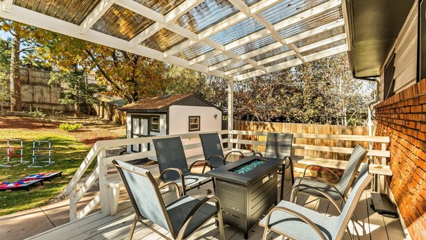 A covered patio with outdoor furniture, a grill, and a small shed in the background. - The Mountain Retreat: Steps to Palmer Park, Central COS, Sleeps 8 (Colorado Springs)