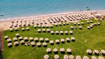 Relax on the beachside lawn with comfortable sun loungers and umbrellas, steps from the sandy beach.