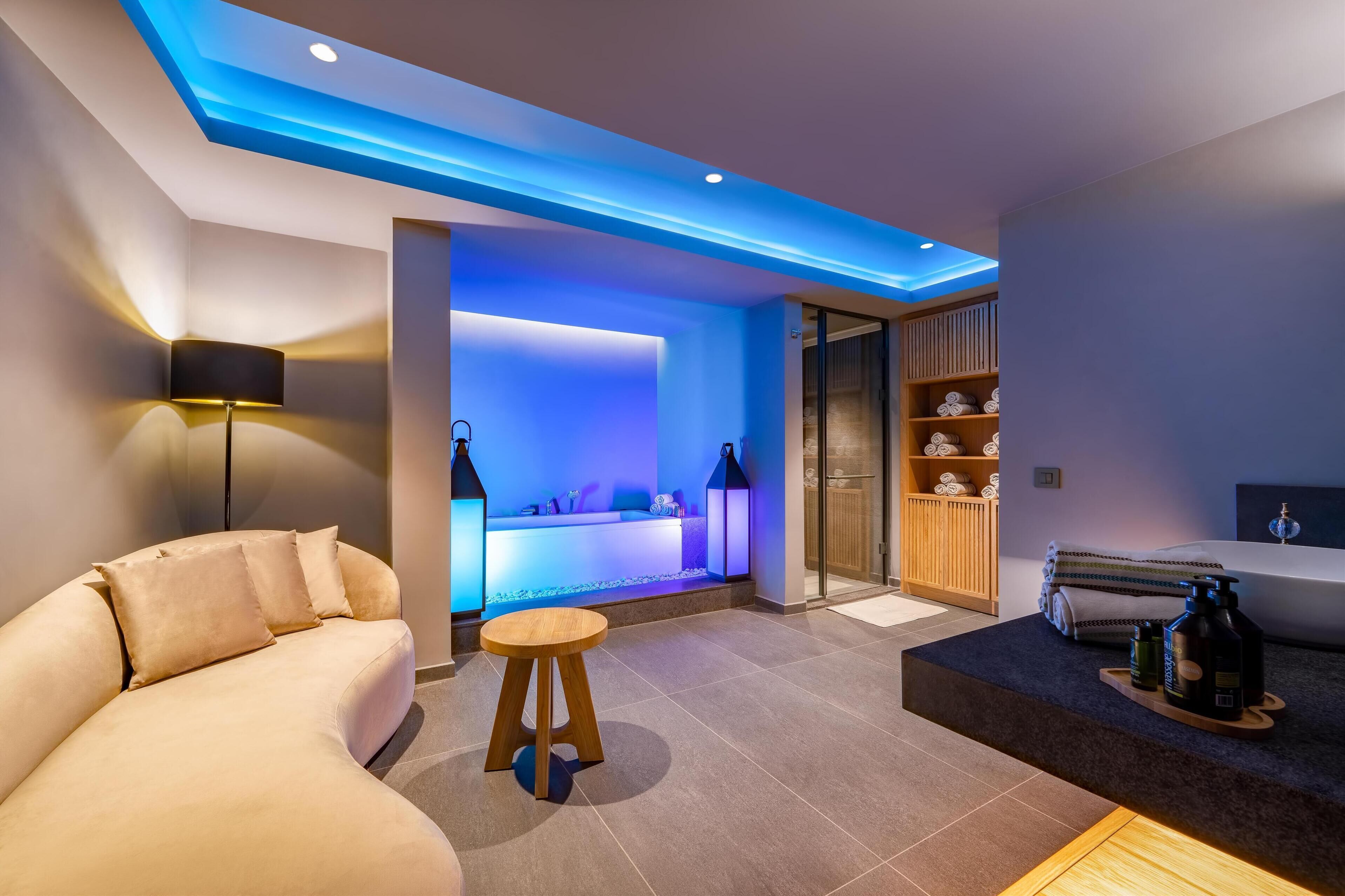 Un moderno spa con una mesa de masaje, una recepción y una estantería de madera con toallas.