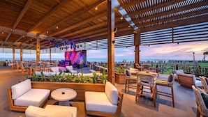 An outdoor lounge area with wooden furniture, a bar, and a view of the sea. - Rixos Park Belek - All Inclusive - The Land of Legends Access (Serik)