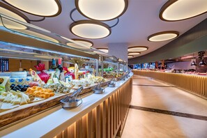 A buffet with various cheeses, fruits, and vegetables.