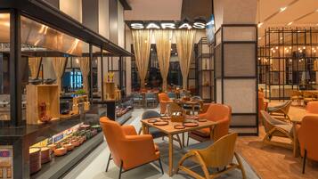 A restaurant interior with a bar area, seating arrangements, and a sign reading 'SARAS.'