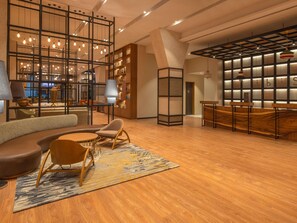 A modern interior with a seating area, wooden flooring, and a bookshelf. - Ibis Thane (Thane)