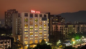 A multi-story hotel with illuminated windows and a prominent "ibis HOTEL" sign. - Ibis Thane (Thane)