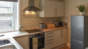 Una cucina moderna con forno a incasso, tostapane e frigorifero.