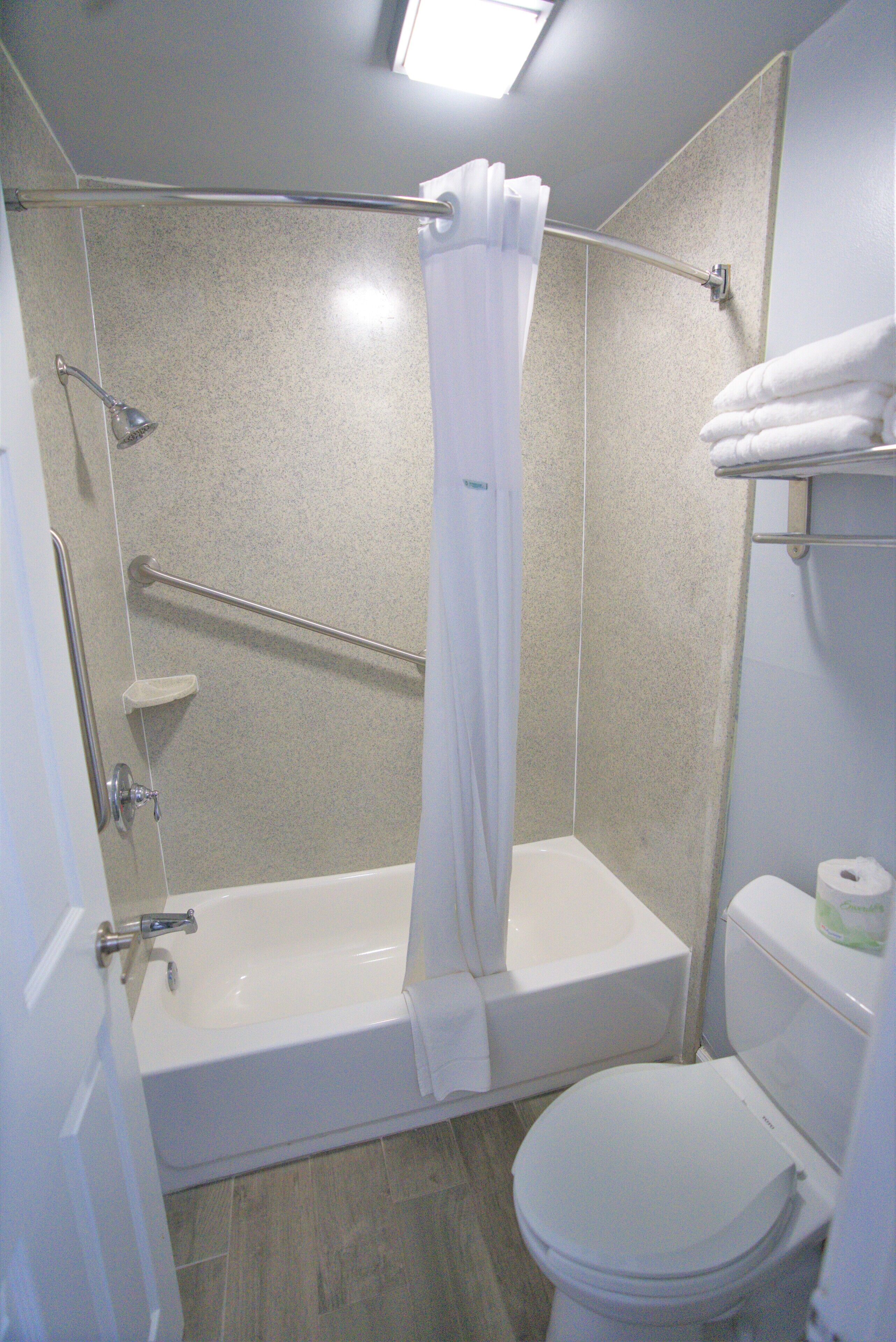 Une salle de bain équipée d’une baignoire, de toilettes et d’un espace douche.