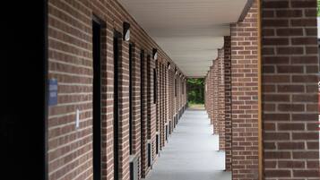 A covered corridor with vending and ice services, brick walls, and a concrete floor.