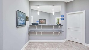 Un área de recepción con mostrador, obras de arte enmarcadas y una puerta.