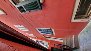 Un edificio rosso con molte finestre e una scala ben visibile.