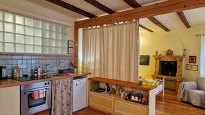 Una cucina compatta con forno integrato, un piccolo frigorifero e un piano di lavoro in legno.