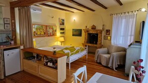 Una camera accogliente con un letto, un tavolino, una sedia, un camino e una televisione.