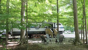 A recreational vehicle (RV) with a dining area, outdoor seating, and a staircase leading to an upper level. - RV Rental #6 Sleeps 6 people (Empire)